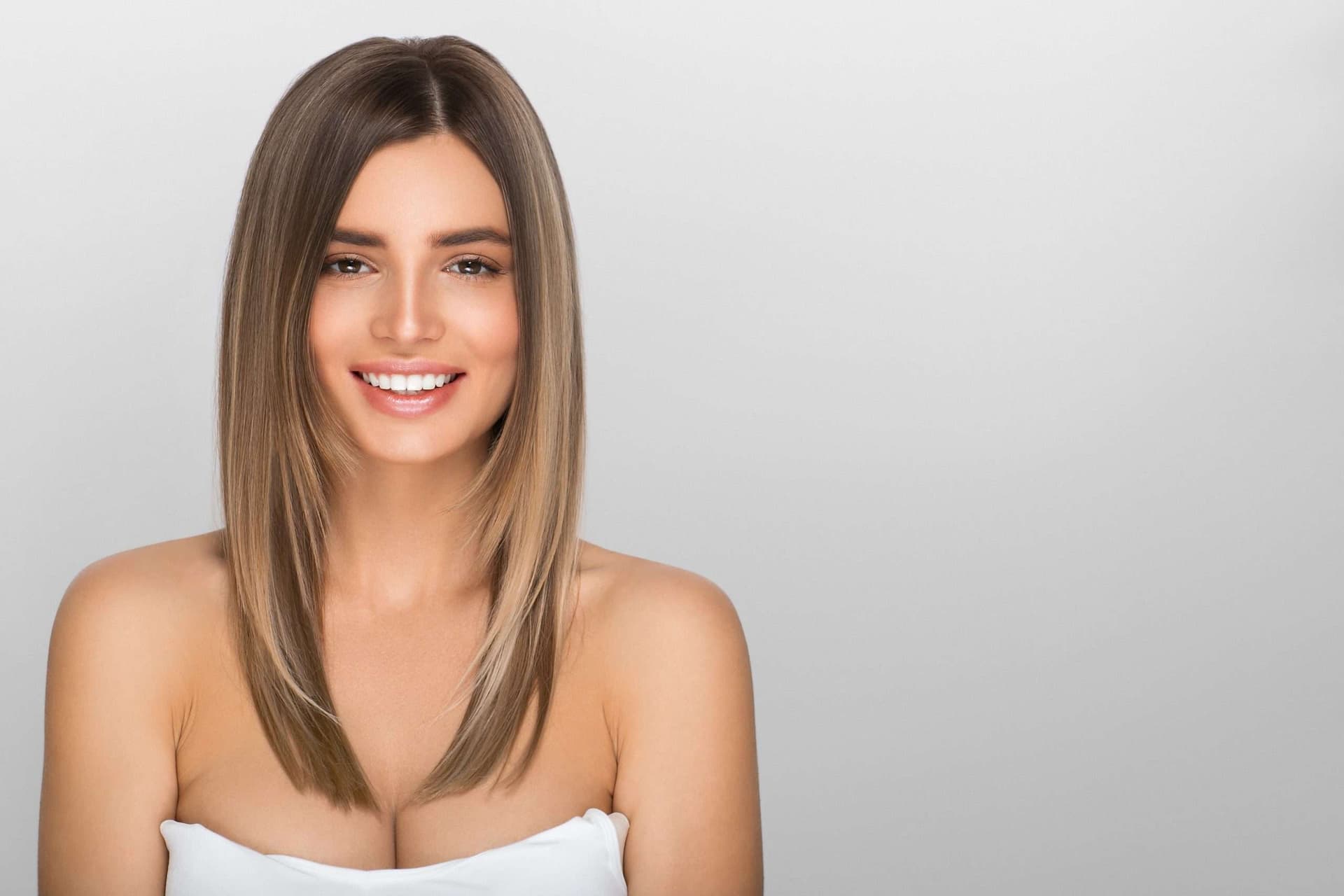 Portret cu par drept, lungime medie, fundal deschis, zambet discret.